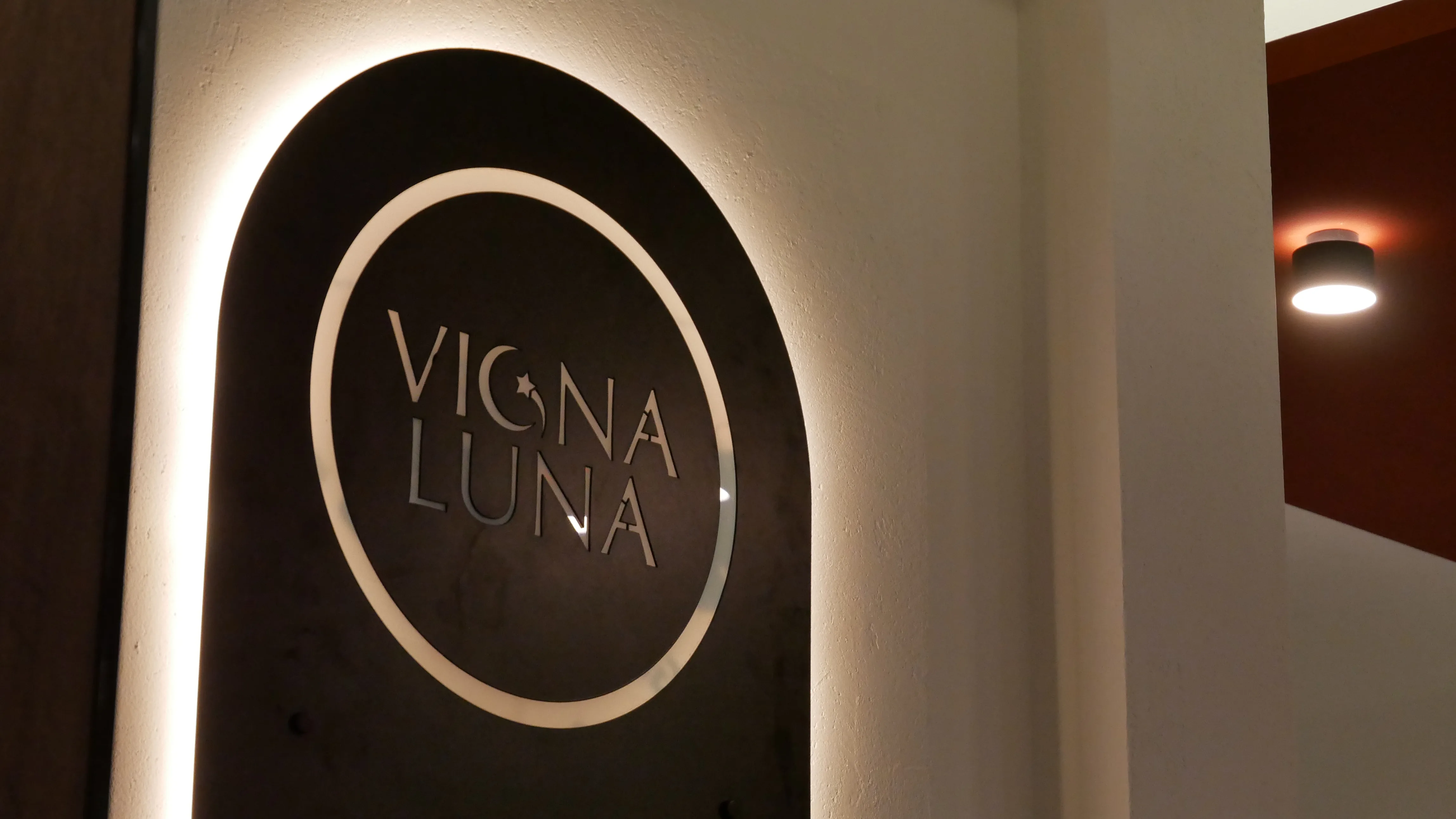 Insegna interna di VIGNALUNA illuminata sulla parete del locale